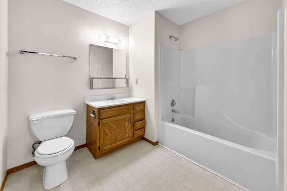 A white toilet sits next to a sink in a bathroom.