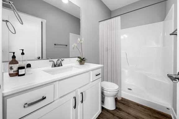 A white bathroom with a toilet, sink, and bathtub.