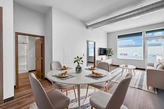 A modern dining room with a round table and chairs.