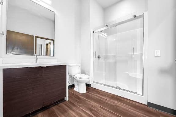 A modern bathroom with a toilet, sink, and shower.