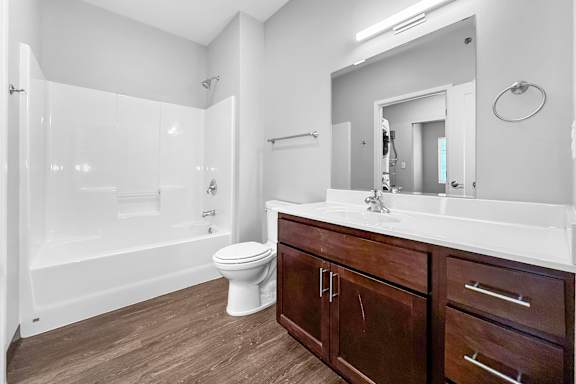 A white bathroom with a toilet, sink, and shower.