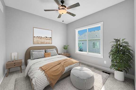 A bedroom with a large bed, a ceiling fan, and a window with a view of a house.