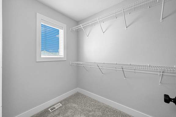 A room with a window and a wall-mounted shelf.