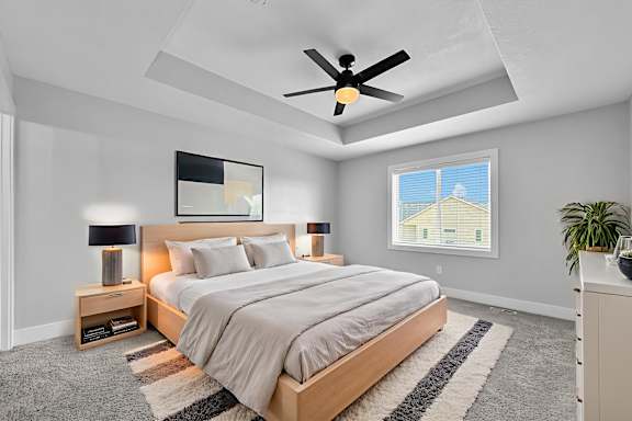 A bedroom with a large bed and a ceiling fan.