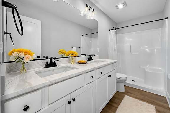A bathroom with a white sink and a white toilet.