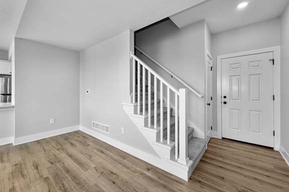 A white door is on the right side of a staircase.