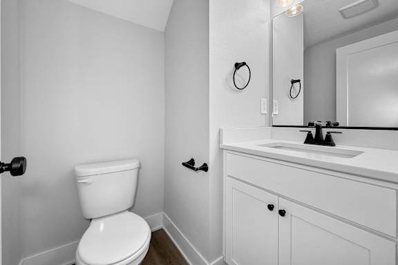 A white toilet sits next to a white sink in a bathroom.