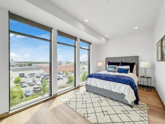 a bedroom with a bed and large windows