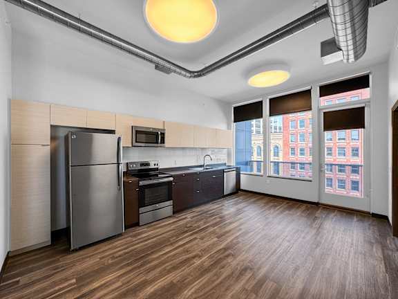 an empty kitchen with stainless steel appliances and a large window