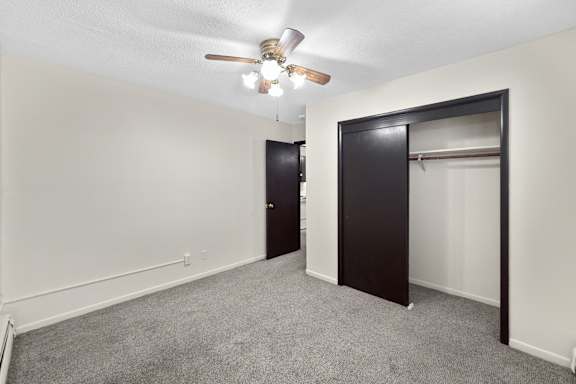 A room with a ceiling fan and two doors.