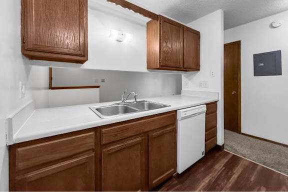 A kitchen with brown cabinets and a white sink.