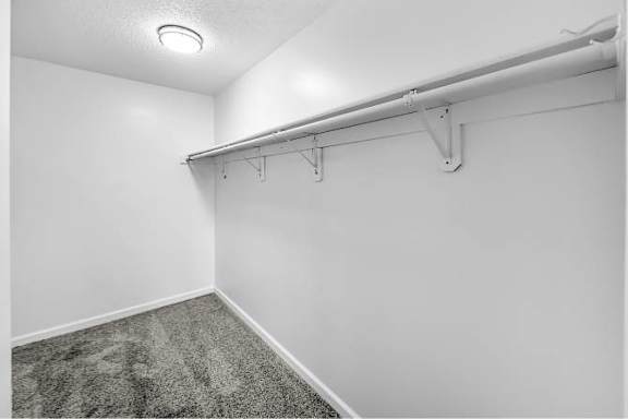 A white room with a carpeted floor and a white wall.