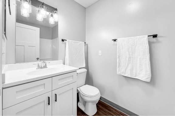 A white bathroom with a toilet, sink, and towel rack.