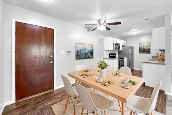 A dining room with a wooden table and chairs.