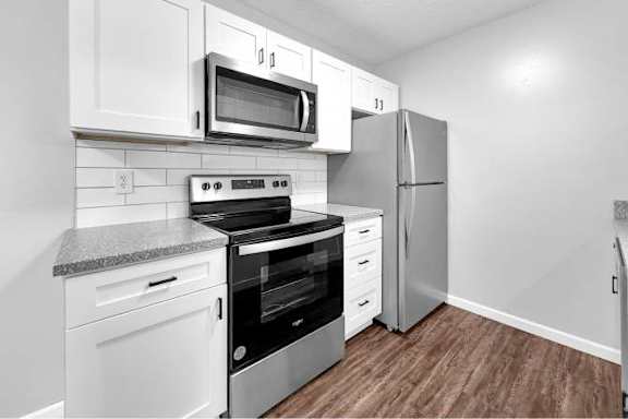 A kitchen with white cabinets and stainless steel appliances.