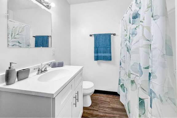 A bathroom with a white counter top and a white sink.