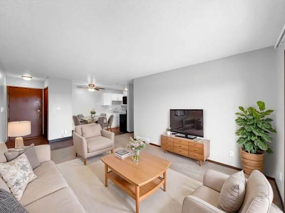 A living room with a couch, chairs, and a television.