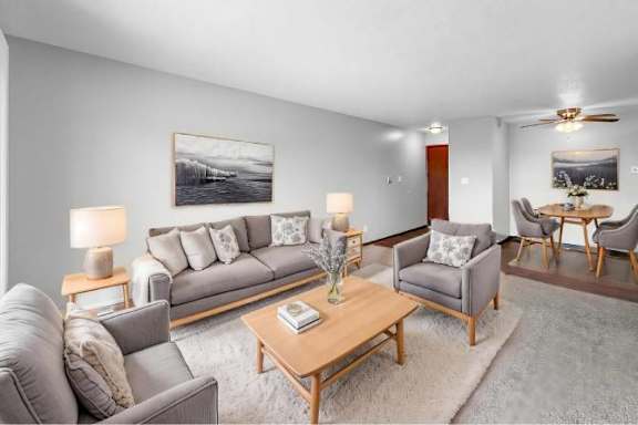 A living room with a grey couch, a coffee table, and a painting on the wall.