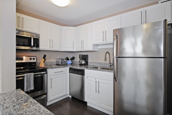 a kitchen with stainless steel appliances and white cabinets