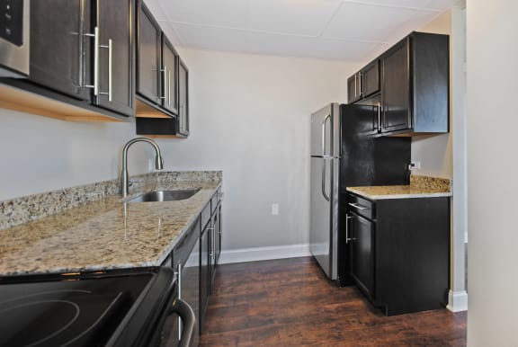 a kitchen with black appliances and granite counter tops and a black refrigerator