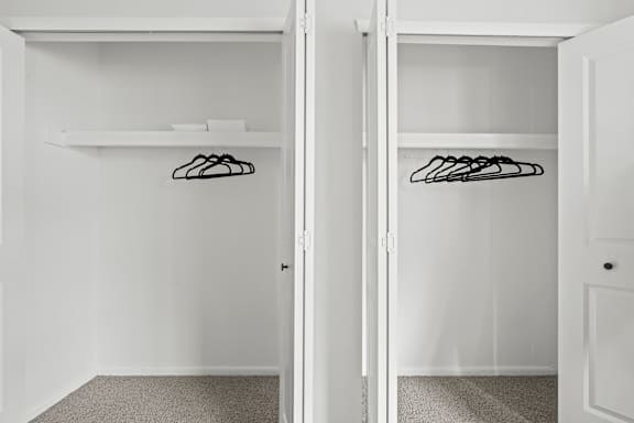 A white closet with two doors and a shelf.