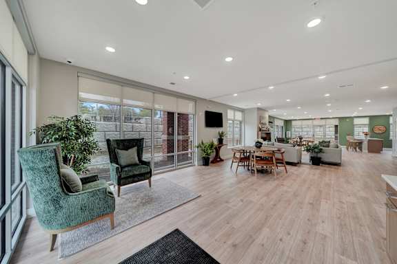 an open living room and dining area with a large window and a table and chairs