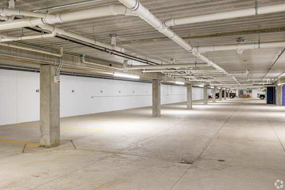 A large, empty parking garage with concrete floors and white walls.