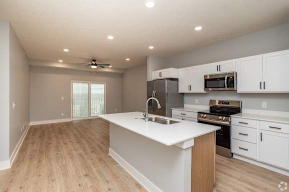 A kitchen with white cabinets and a wooden island.