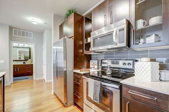 A modern kitchen with stainless steel appliances and wooden cabinets.