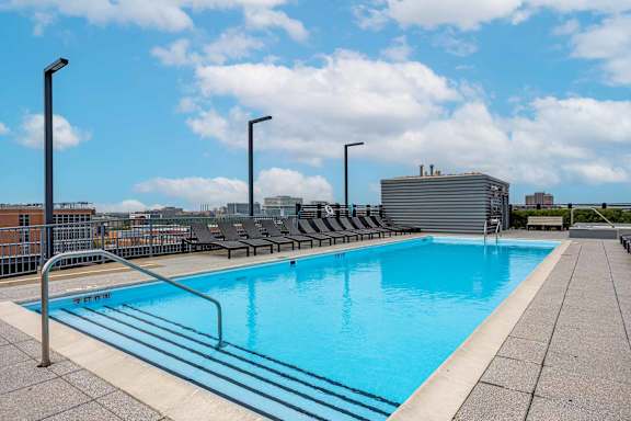 A large outdoor swimming pool with a metal railing around it.