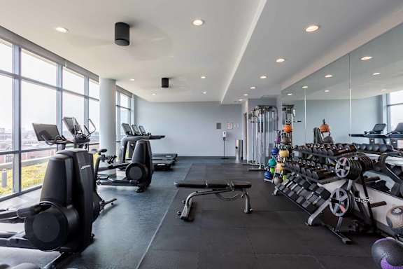 A gym with treadmills, elliptical machines, and other exercise equipment.