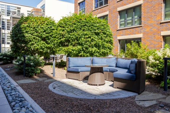 Seating area with a couch and a table in a courtyard at The Madison at Racine, Chicago, Illinois