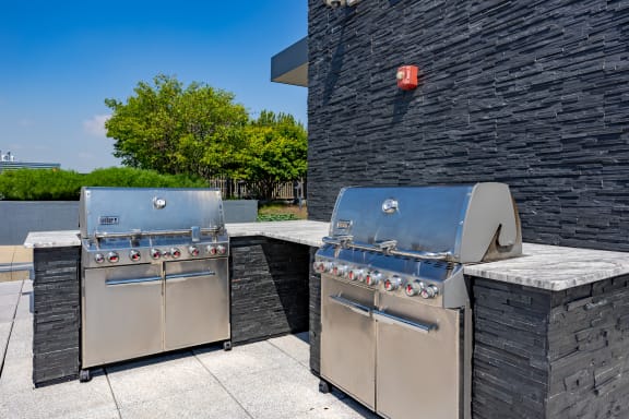 Two stainless steel barbecue grills on a patio at The Madison at Racine, Chicago