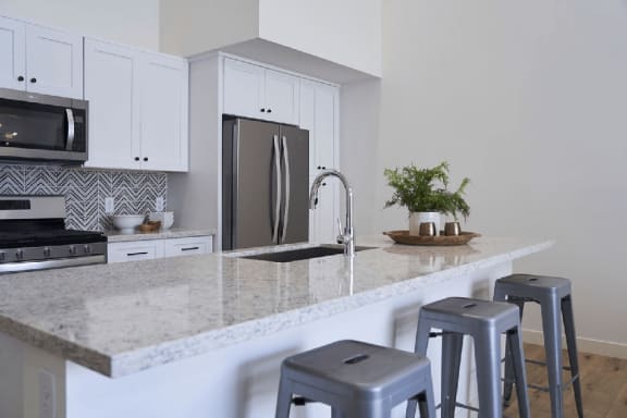 a kitchen with bar stools and a granite counter top at Novella Biltmore, Arizona, 85016