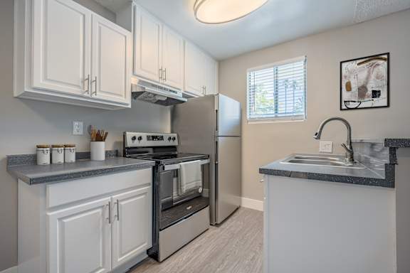 A kitchen with white cabinets and a black stove top oven.