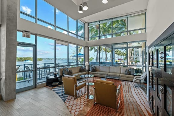 a living room with a large amount of windows overlooking a body of water