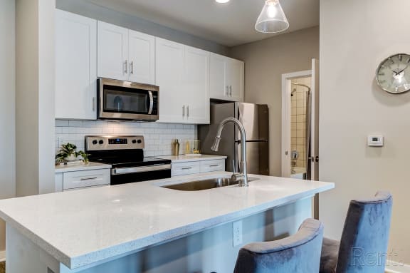 a kitchen with white cabinets and a white counter top