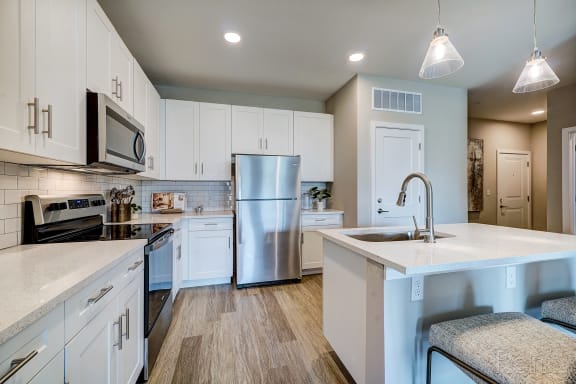 a kitchen with white cabinets and stainless steel appliances