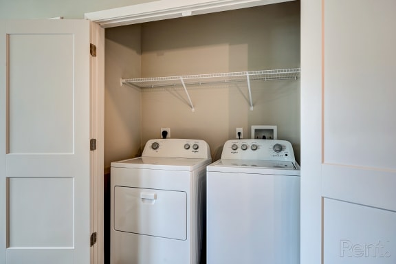 a laundry room with two washers and a dryer