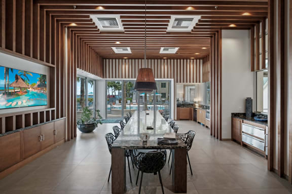 a long dining room with a long table and chairs and a large painting on the