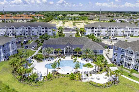 A large resort with a pool and palm trees.