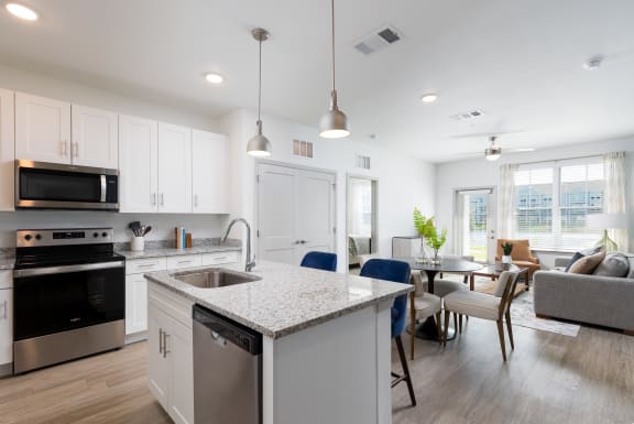 a kitchen and living room with an island and a table with chairs