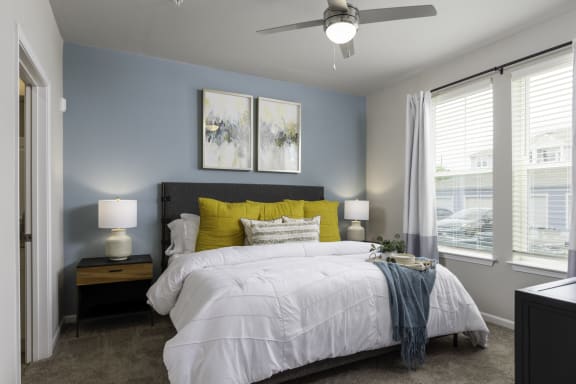a bedroom with a large bed and a ceiling fan