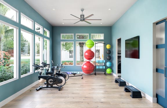 a home gym with ample windows and hardwood flooring