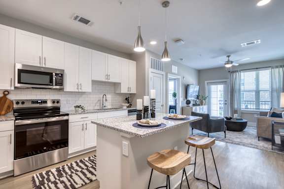 A modern kitchen with a large island and stools.
