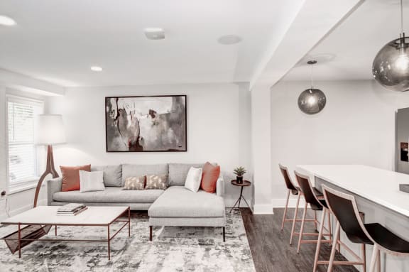 a living room with white walls and hardwood floors at Hamilton at Kings Place, Maryland