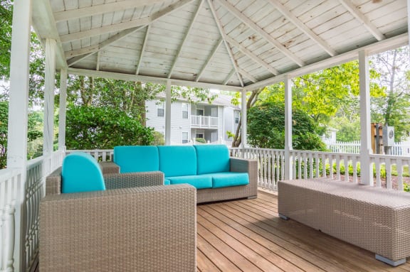 a wraparound porch with wicker furniture and a white pergola  at Hamilton at Kings Place, Columbia, MD 21046