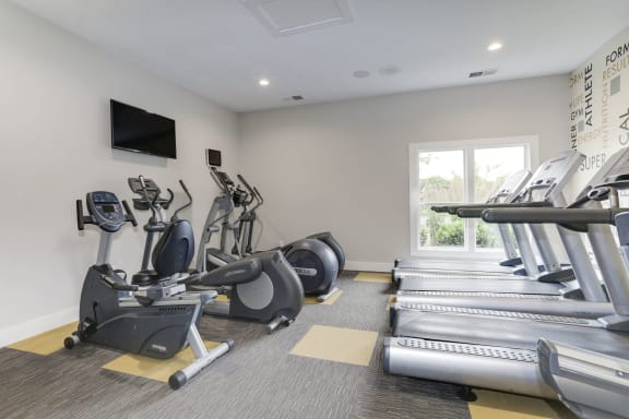 a gym with cardio equipment and a flat screen tv at Madison at Eden Brook, Columbia Maryland