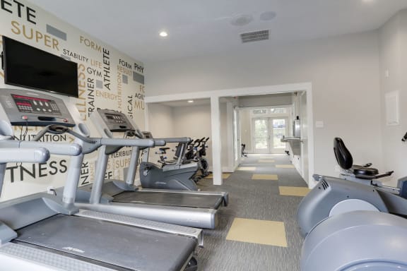 a gym with cardio equipment and a wall of black and white graffiti at Madison at Eden Brook, Columbia, 21046