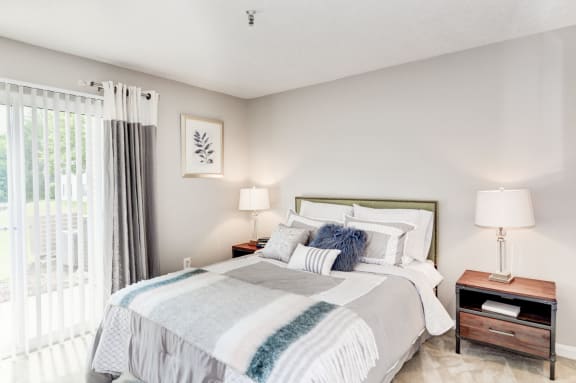 a bedroom with a bed and two night stands with lamps at Hamilton at Kings Place, Maryland